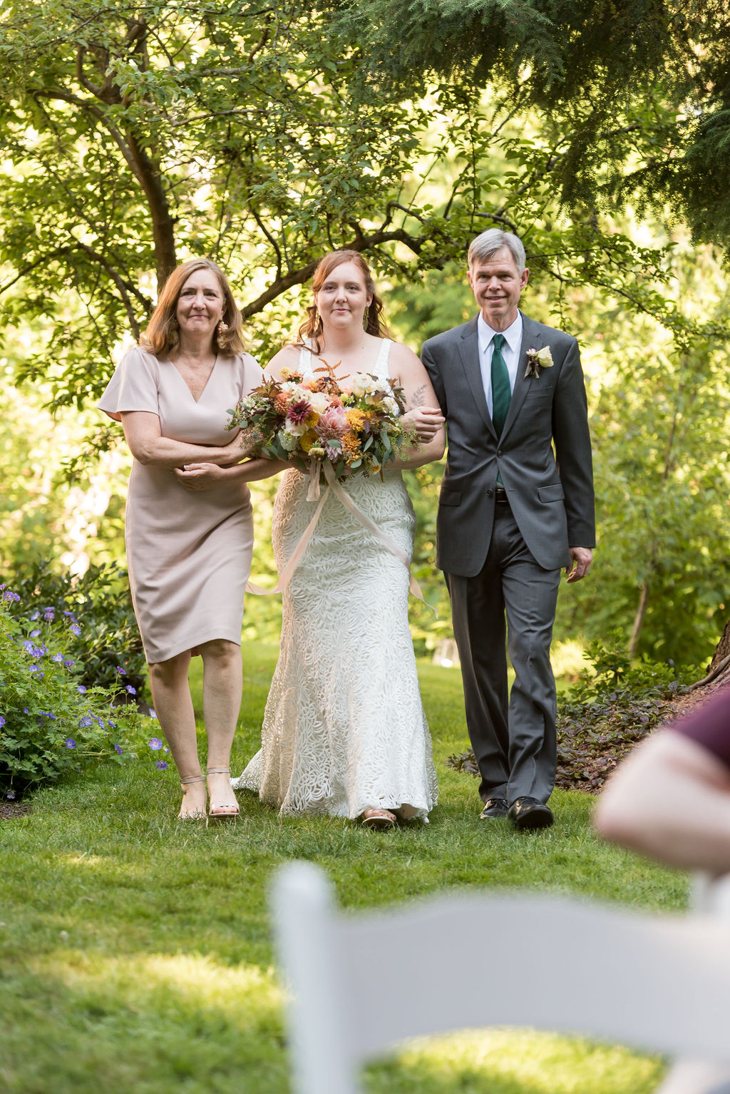 Bride talking down the aisle with parents