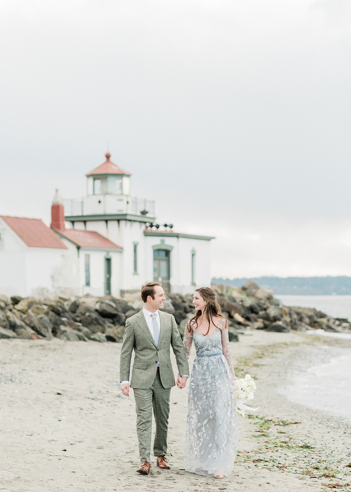 Discovery Park lighthouse in distance with couple walking