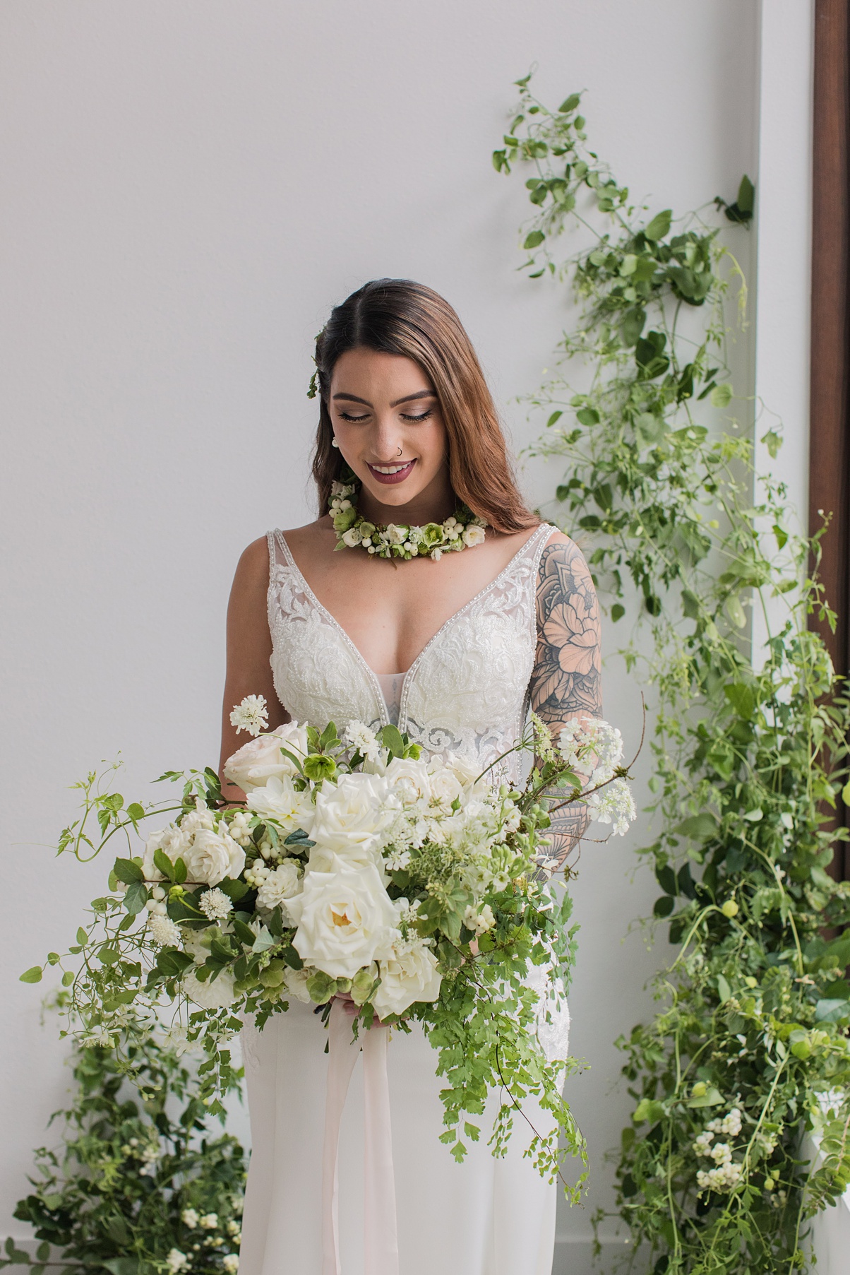 Modern-White-Wedding-Bride-Holding-Bouquet A bride holding a white bouquet in front of a floral installation