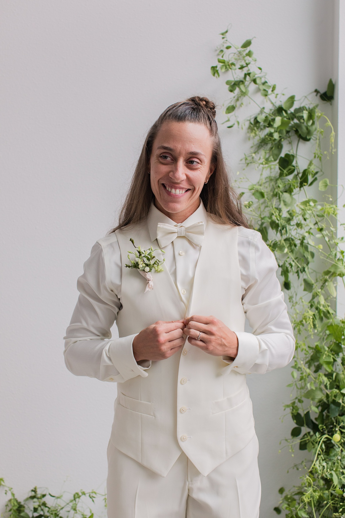 Modern-White-Wedding-Getting-Ready A bride getting ready standing in front of a floral installation