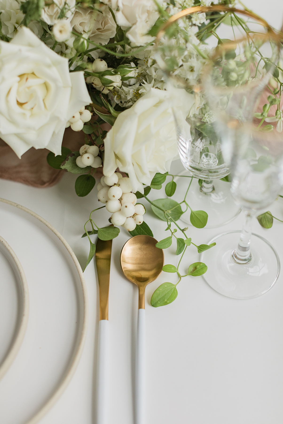 Modern-White-Wedding-Place-Setting A place setting with gold silverware and white floral centerpiece