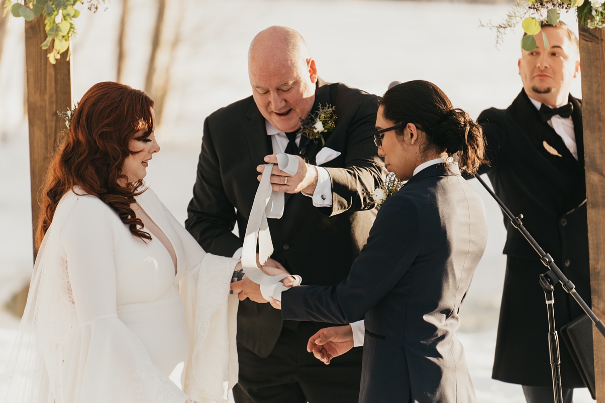 Winter-Destination-Wedding-Mountain-Springs-Lodge-Handfasting The beginning of the handfasting ceremony with hand-dyed silk ribbon