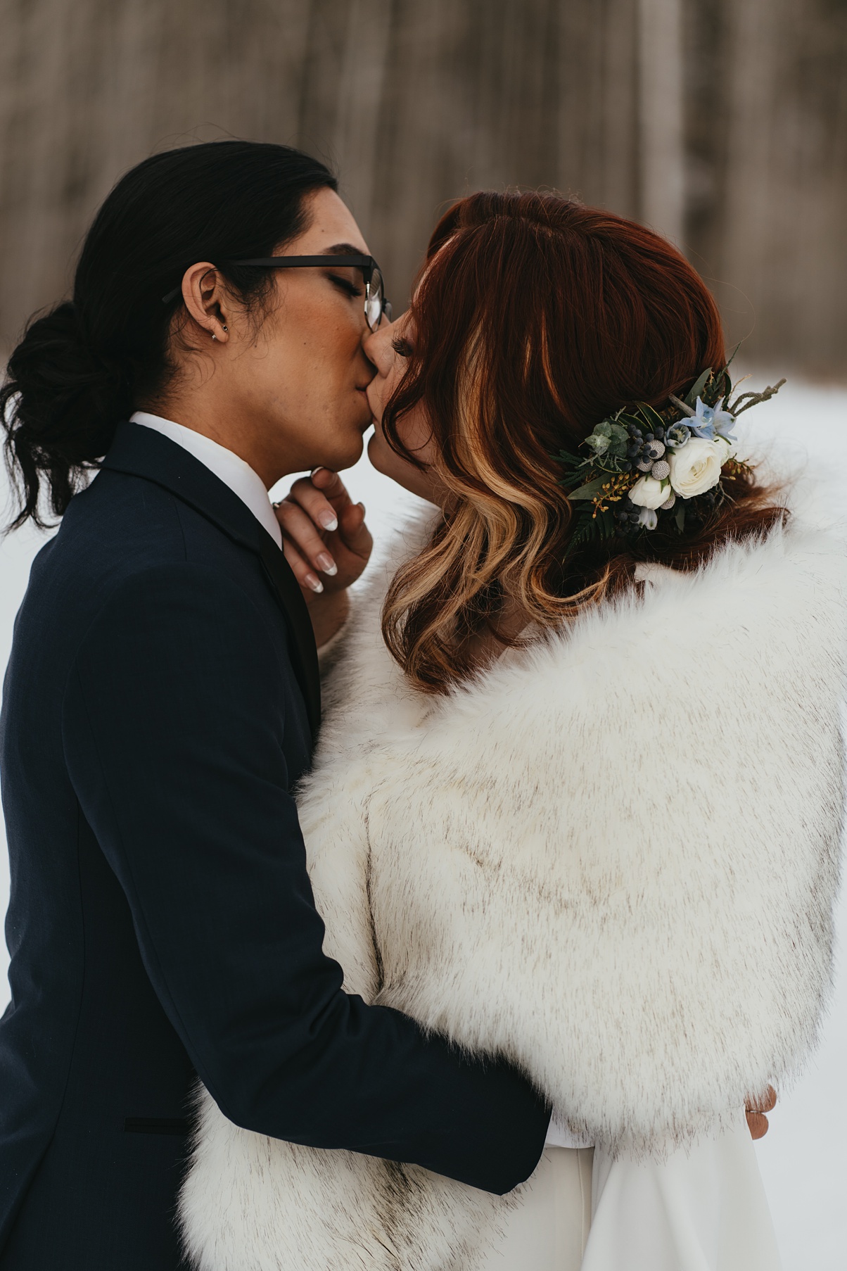 The couple kissing outside in the snow