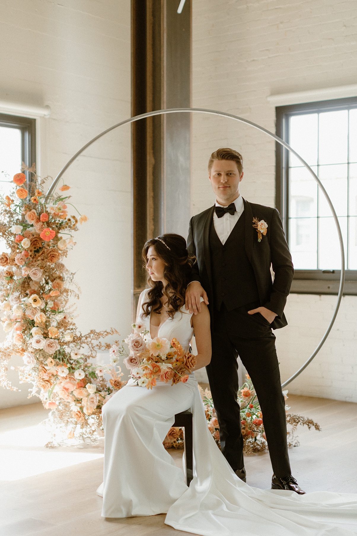 The couple stands in front of the ceremony arch at a Block 41 wedding