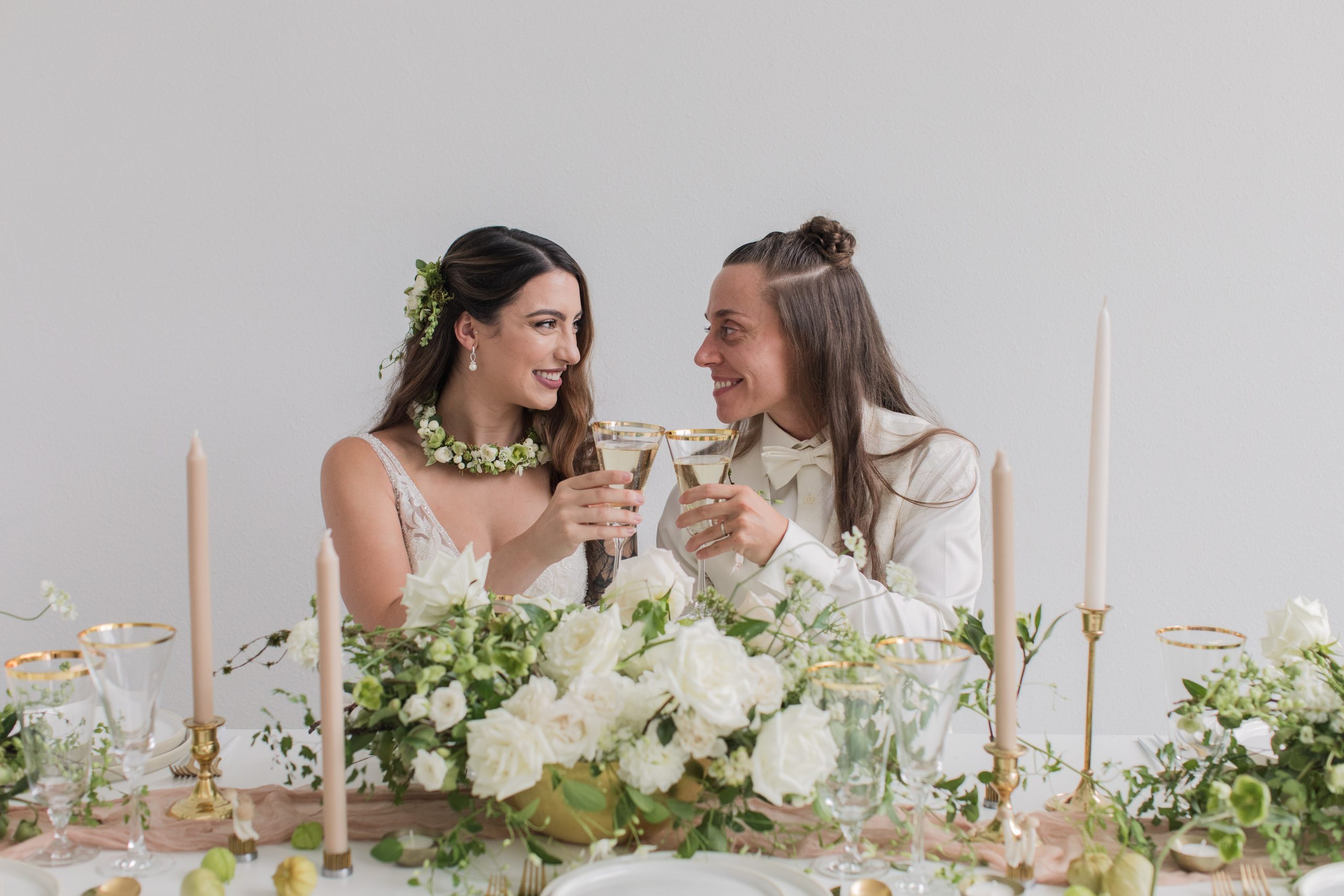 Modern-White-Wedding-Brides-Toasting A modern white wedding with two brides toasting champagne