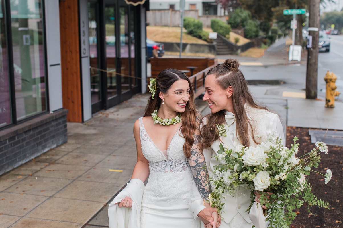 Modern-White-Wedding-Couple-Embracing-Outdoors-Just-Married A couple embraces outside of their white wedding ceremony, just married