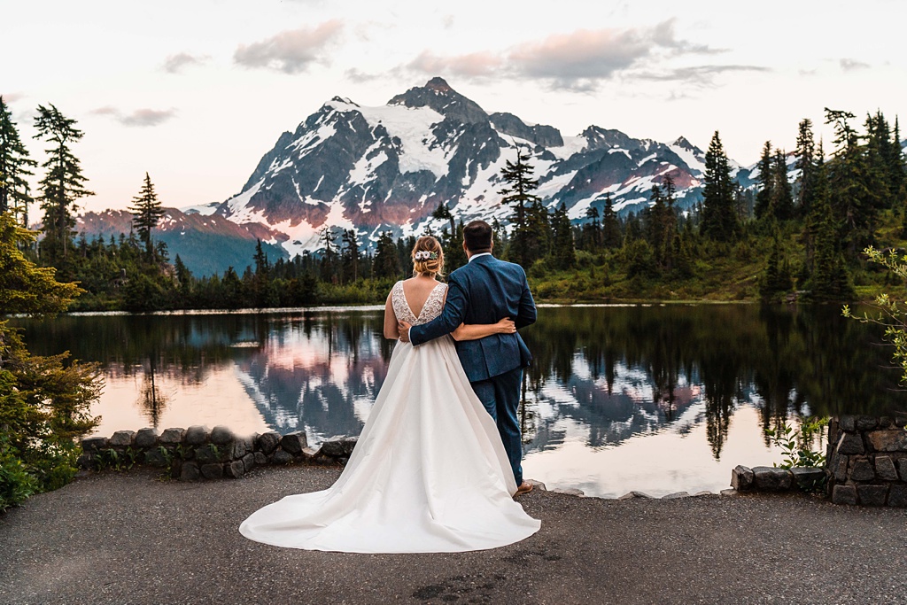 Mountain-Wedding-with-Vibrant-Summer-Blooms-Sunset-Lake-Embrace A couple embraces at sunset at an alpine lake