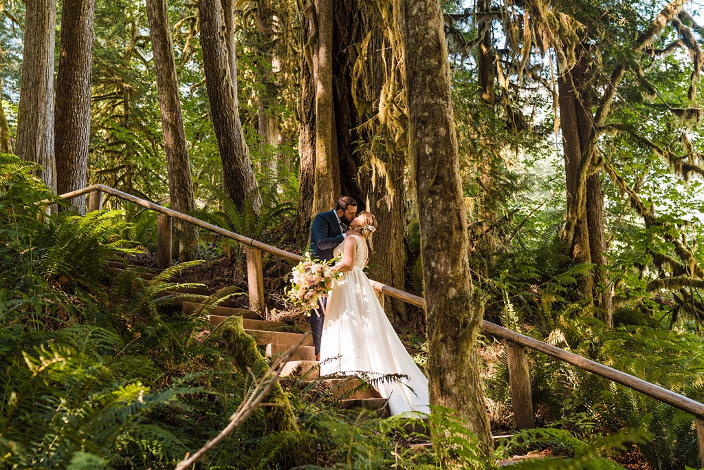 Mountain-Wedding-with-Vibrant-Summer-Blooms-Trail-Kiss The couple kisses on a woodland trail