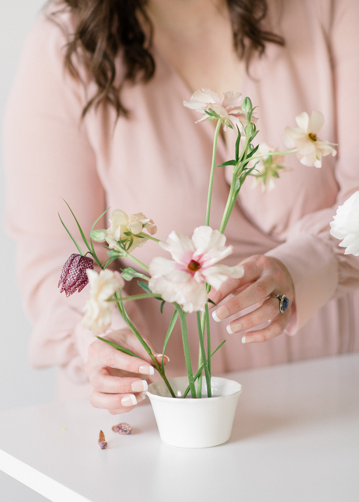 Owner Carolyn Kulb arranging blush flowers