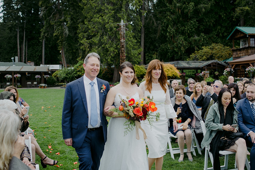 The bride is walked down the aisle at this Kiana Lodge wedding