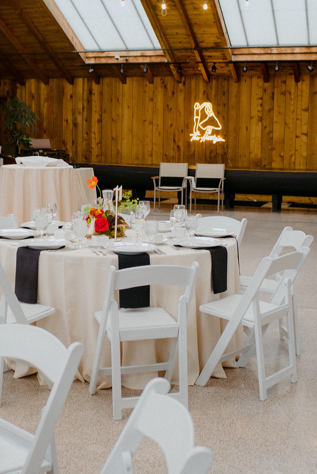 The indoor part of the lodge set up with neon sign and florals