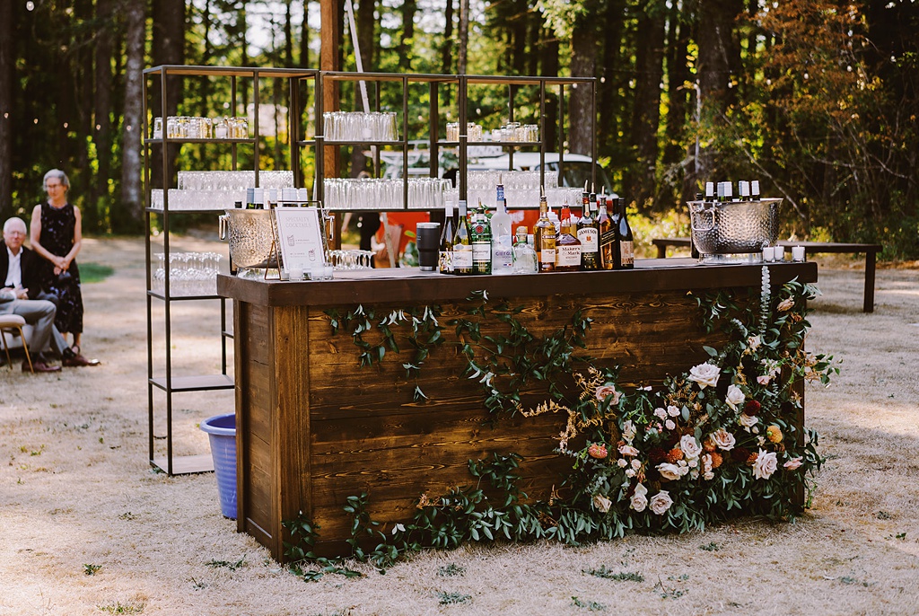 Bloom-Poet-Seattle-Wedding-Florist-Summer-Wedding-Bar-Flowers.jpg Summer wedding flowers on the bottom of a wooden bar