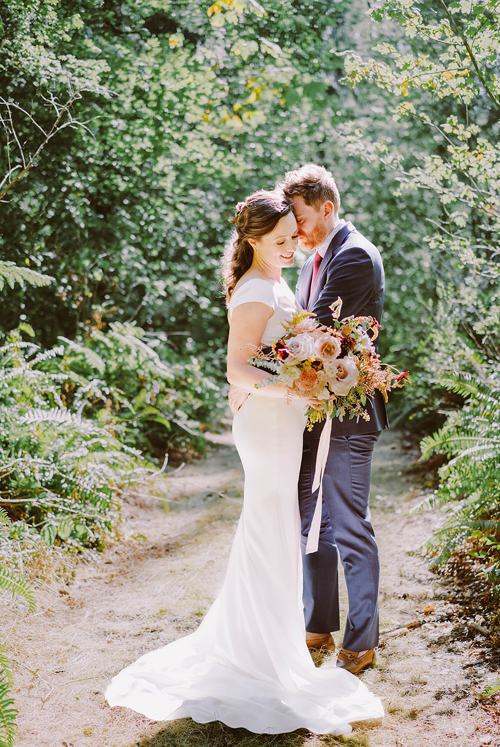Bloom-Poet-Seattle-Wedding-Florist-Summer-Wedding-Bouquet-in-Woods.jpg The couple stands in the woods, holding a summer wedding bouquet