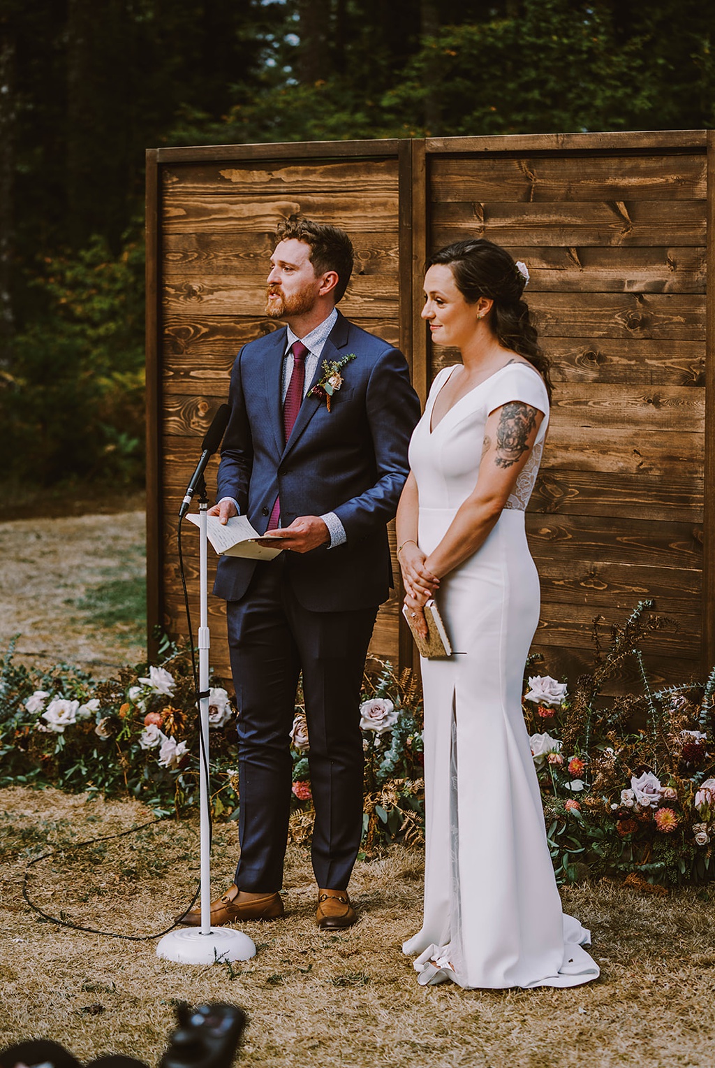 Bloom-Poet-Seattle-Wedding-Florist-Summer-Wedding-Ceremony-Backdrop.jpg The bride and groom stand in front of their floral ceremony backdrop at their summer wedding