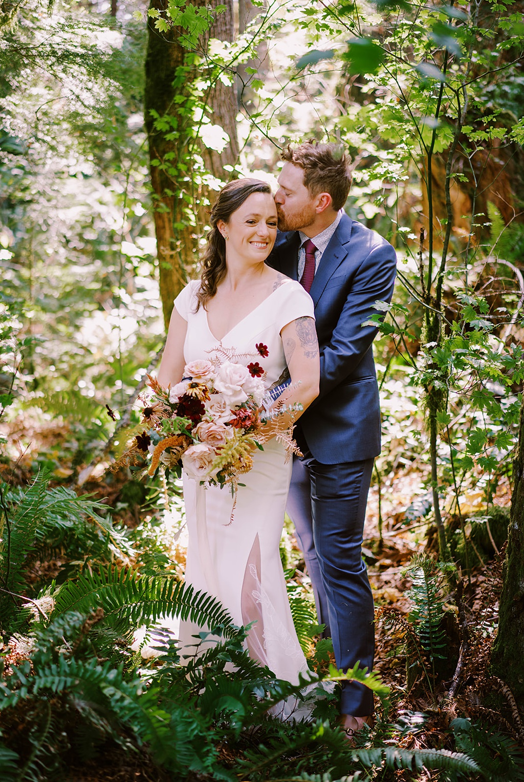 Bloom-Poet-Seattle-Wedding-Florist-Summer-Wedding-Forest-Portrait.jpg The couple stands in the forest holding the bridal bouquet
